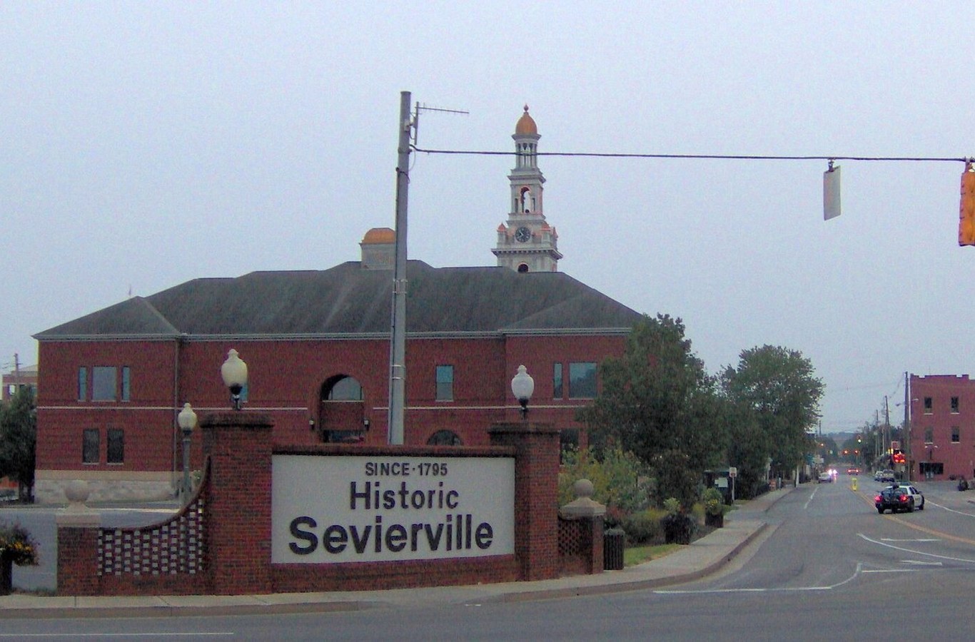 Historic Sevierville sign at the entrance to downtown Sevierville, TN, with the courthouse tower behind