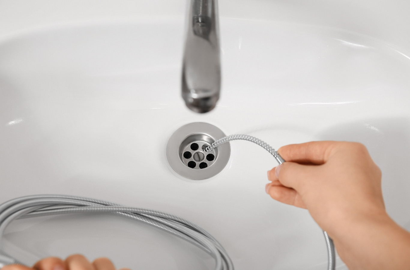 Drain cable fed into a white basin, a fix Starling Plumbing makes in White Pine, TN. Drain & Sewer Services Near Me.