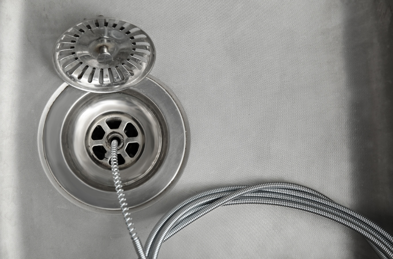 Drain cable in a steel sink drain, as Starling Plumbing does in Bean Station, TN. Drain & Sewer Services Near Me.