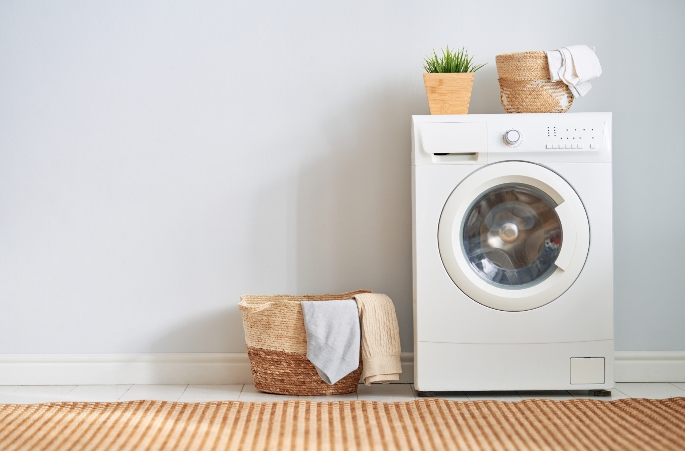 Front-load washer and laundry basket in a bright laundry room, hot water use Starling Plumbing plans for in Blaine, TN