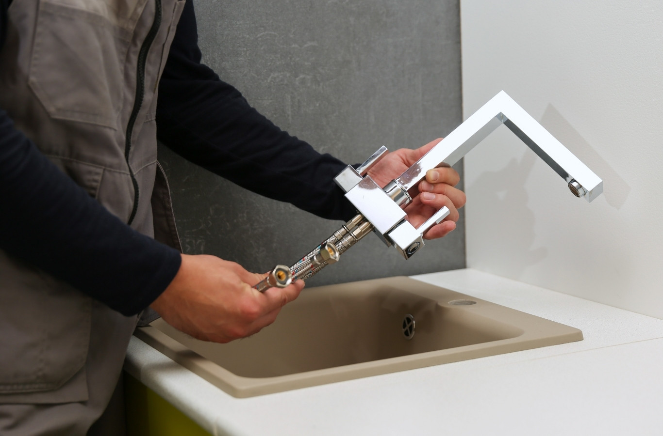 Hands installing a new chrome faucet at a sink, fixture work by Starling Plumbing in White Pine, TN. Plumber Near Me.