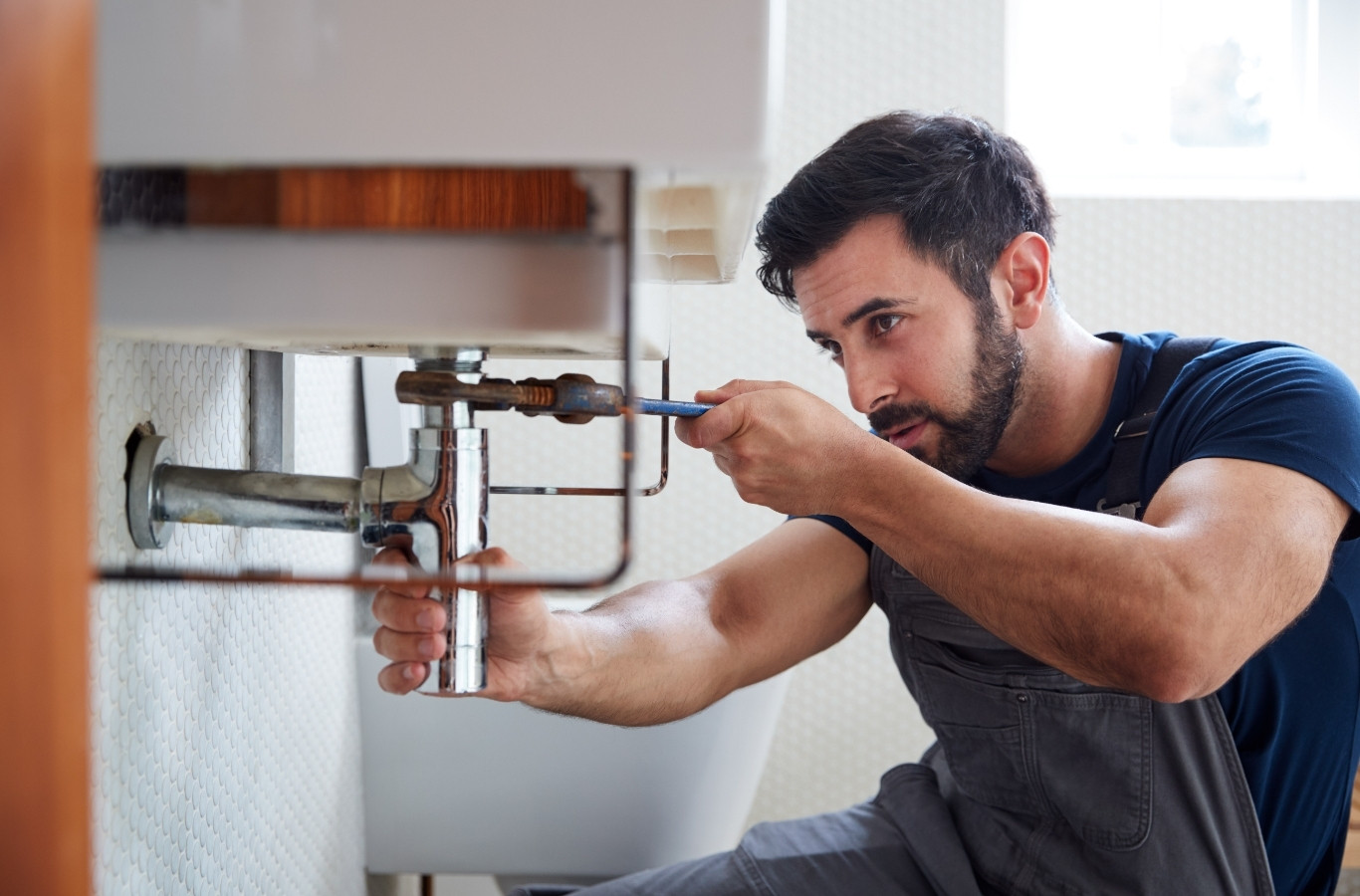 Plumber adjusting the supply valve under a bathroom sink, a leak repair Starling Plumbing handles in Hamblen County, TN