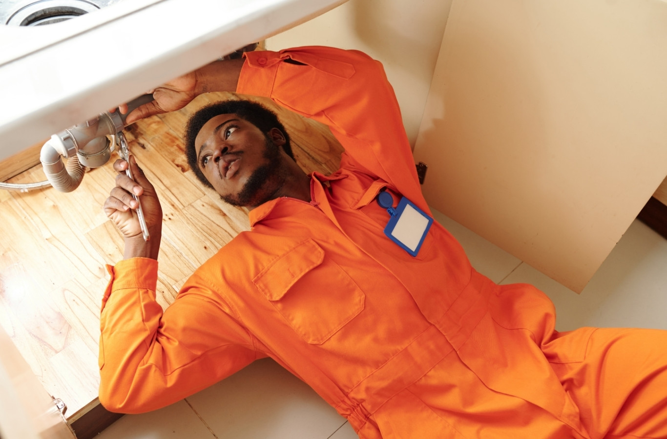 Plumber lying under a sink cabinet to reach the pipes, an everyday repair Starling Plumbing handles in Seymour, TN