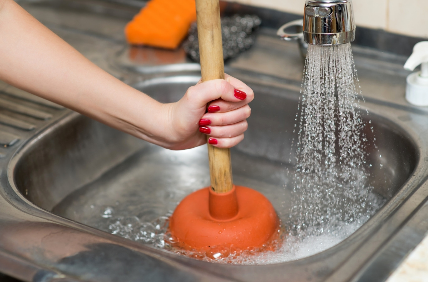 Plunger working in a steel kitchen sink under the faucet, the kind of backup Starling Plumbing clears in Blaine, TN