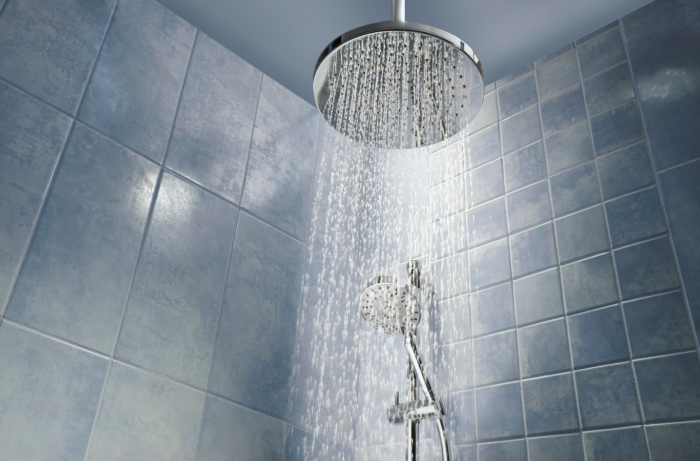 Rain shower running in a tiled bathroom, hot water guests expect from Starling Plumbing in Sevierville, TN