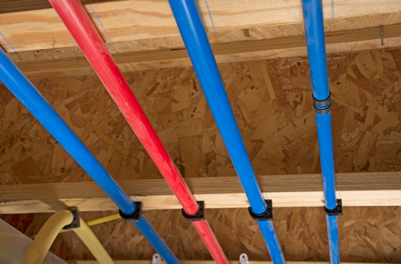 Red and blue PEX water lines in floor joists, the kind of piping Starling Plumbing installs in Jefferson City, TN