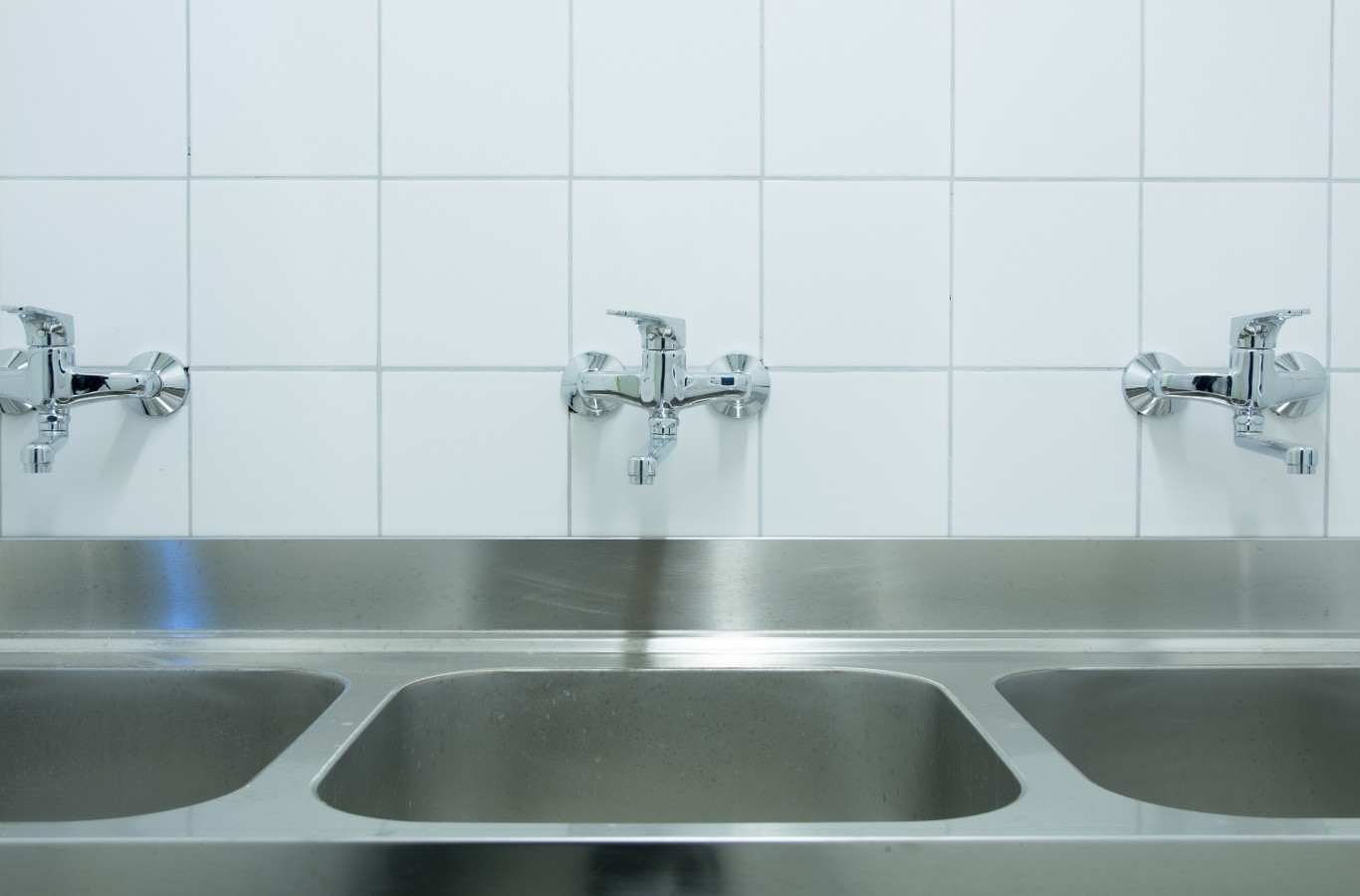 Row of stainless steel sinks in a commercial kitchen, the busy lines Starling Plumbing keeps clear in Sevierville, TN