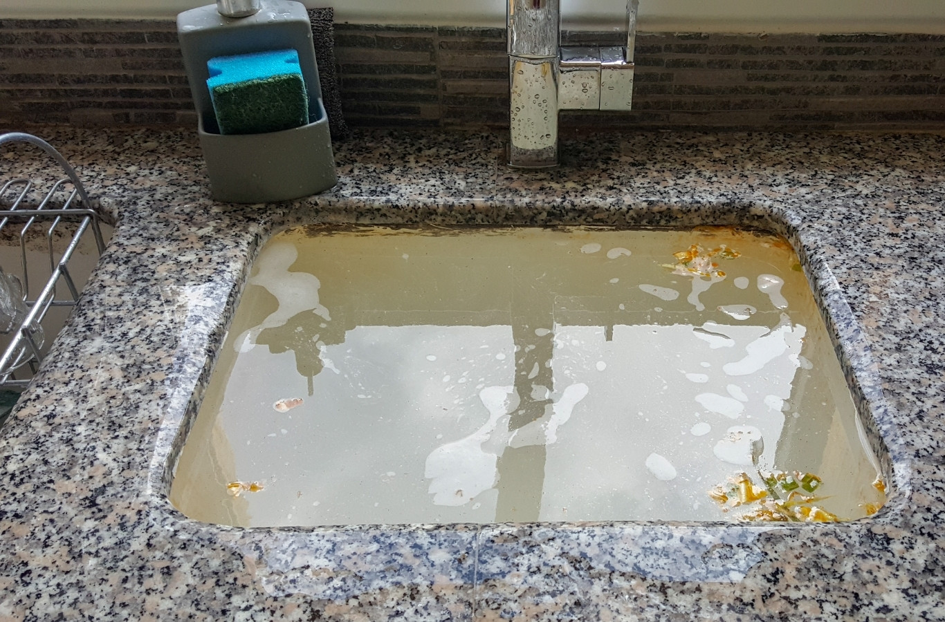 Standing water in a sink set into a granite countertop, a slow drain Starling Plumbing clears in Kodak, TN homes