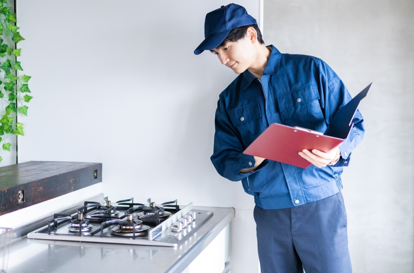 Technician with a clipboard inspecting a gas cooktop, a gas check Starling Plumbing does in Morristown, TN