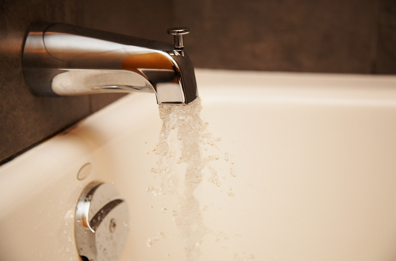 Tub spout filling a white bathtub with warm water, the hot water Starling Plumbing helps families keep in Newport, TN
