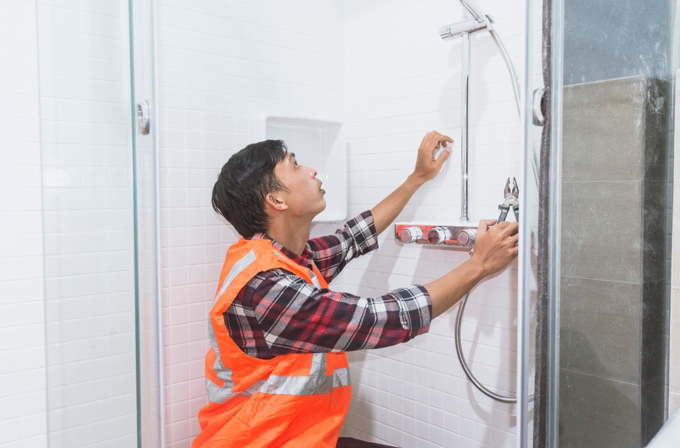 Worker installing a shower valve and fixtures, bathroom work by Starling Plumbing in Seymour, TN. Plumber Near Me.