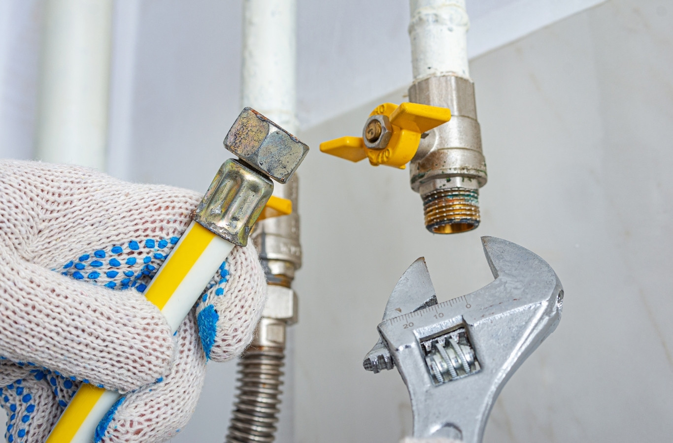 Gloved hand and wrench on a gas valve fitting, safe line work by Starling Plumbing in New Market, TN. Plumber Near Me.
